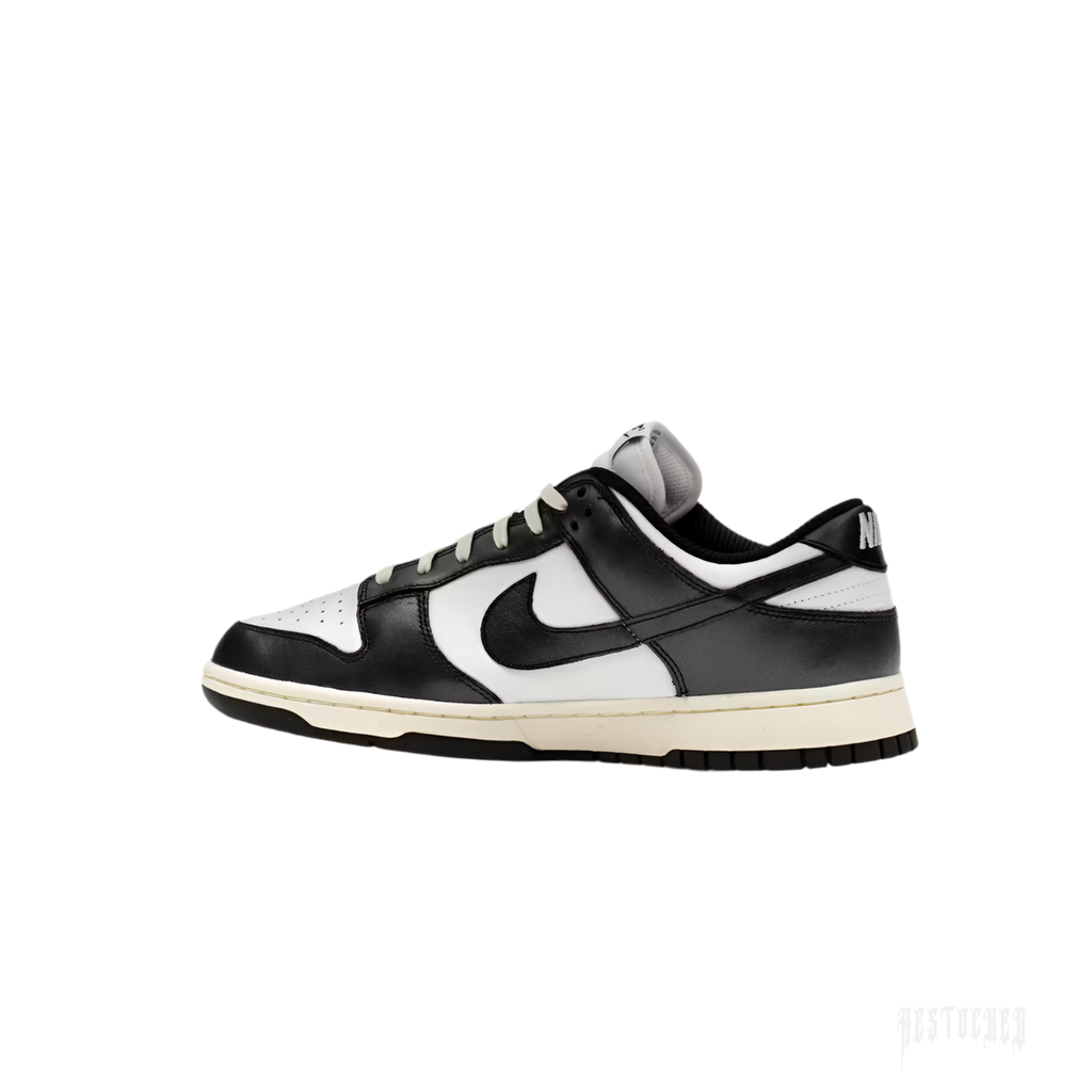 NIKE DUNK LOW VINTAGE PANDA women's sneaker, black and white leather with cream midsole.