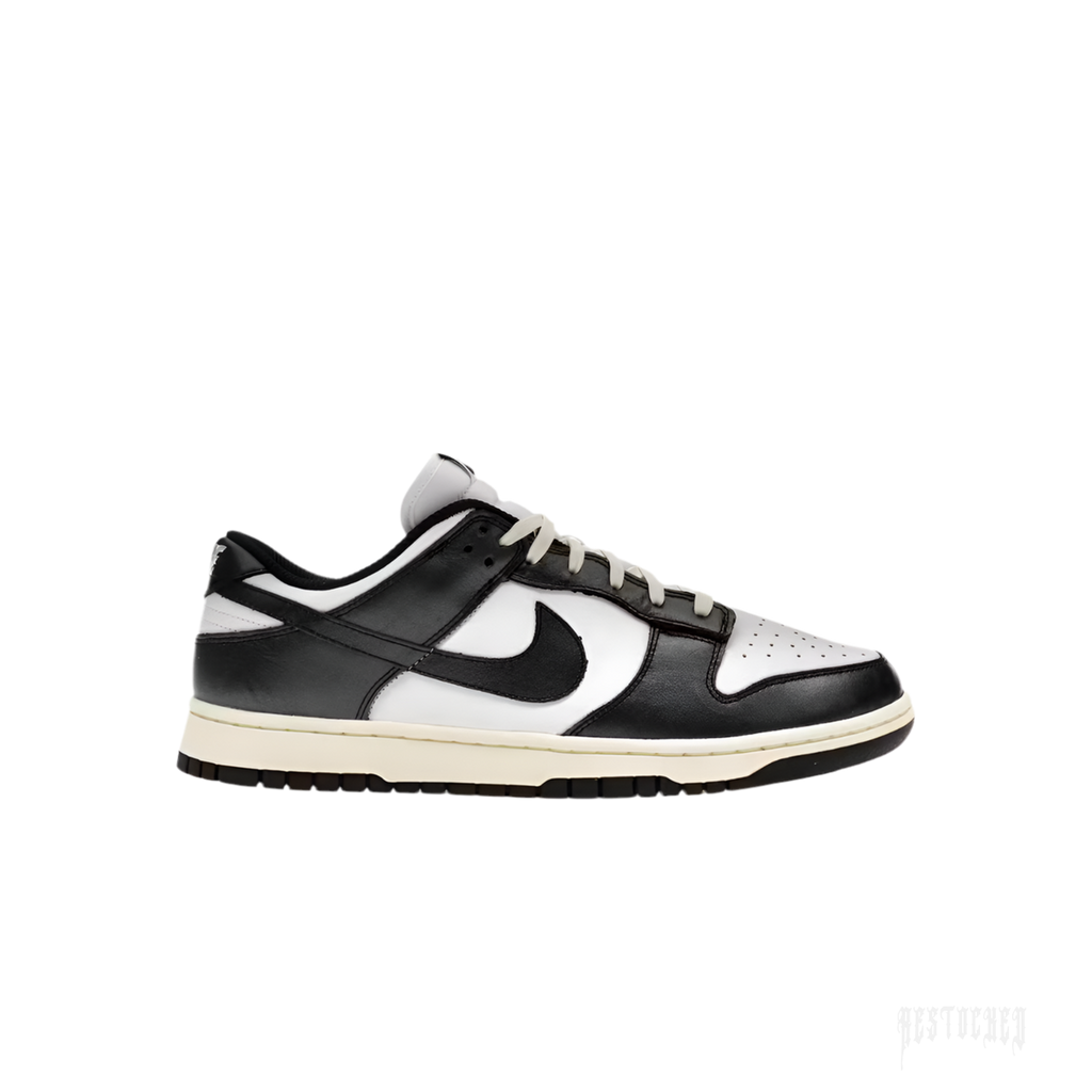 NIKE DUNK LOW VINTAGE PANDA women's sneaker, black and white leather, side view, cream laces and sole.