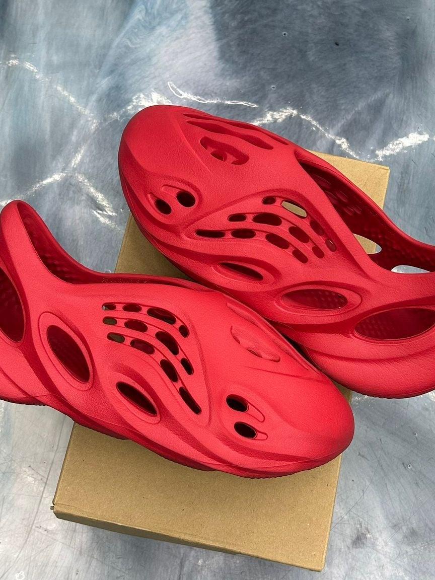 Pair of pre-owned ADIDAS YEEZY FOAM RNNR Vermilion size 9, vibrant red with signature perforations.