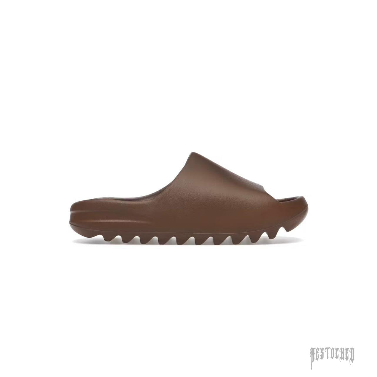 ADIDAS YEEZY SLIDE FLAX in brown, featuring a smooth upper and a ridged, wavy sole.