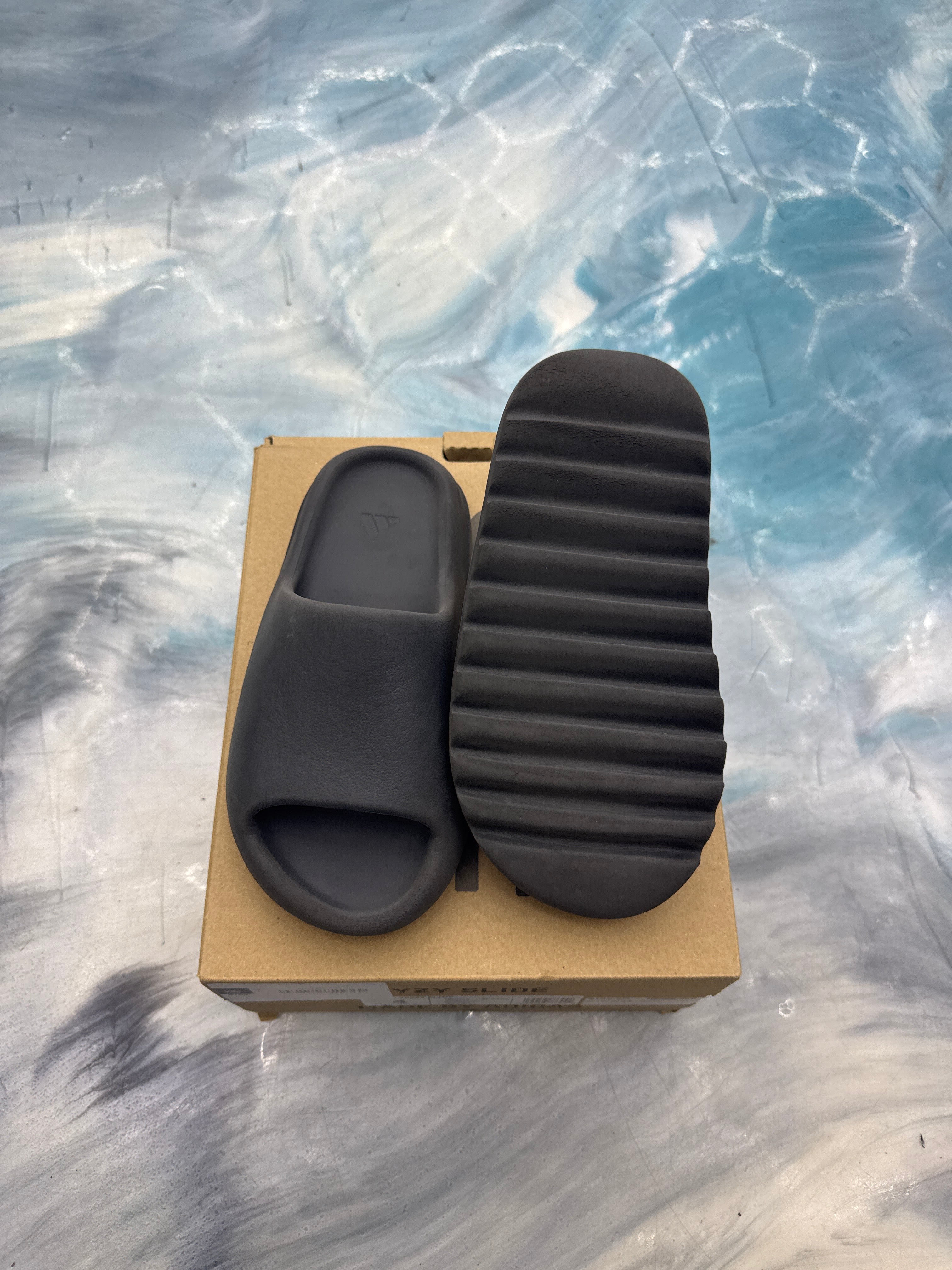 Adidas Yeezy Slide Onyx, pre-owned size 4, dark gray foam slide on a cardboard box.