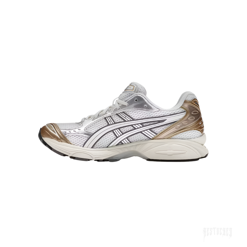 ASICS GEL-KAYANO 14 "Olympic Medals" sneaker with white mesh, cream leather, and metallic gold accents.