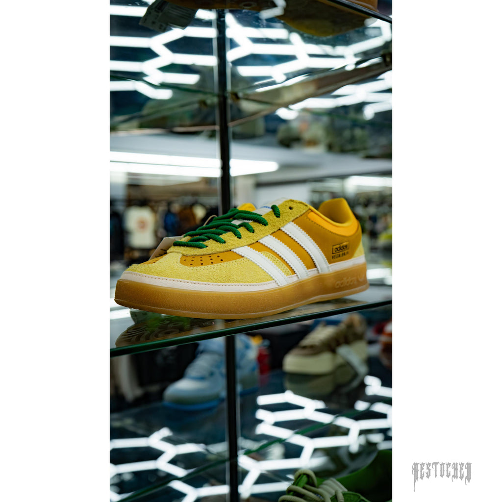 Bad Bunny Adidas Gazelle Indoor Vega Baja in yellow suede with white stripes and green laces.