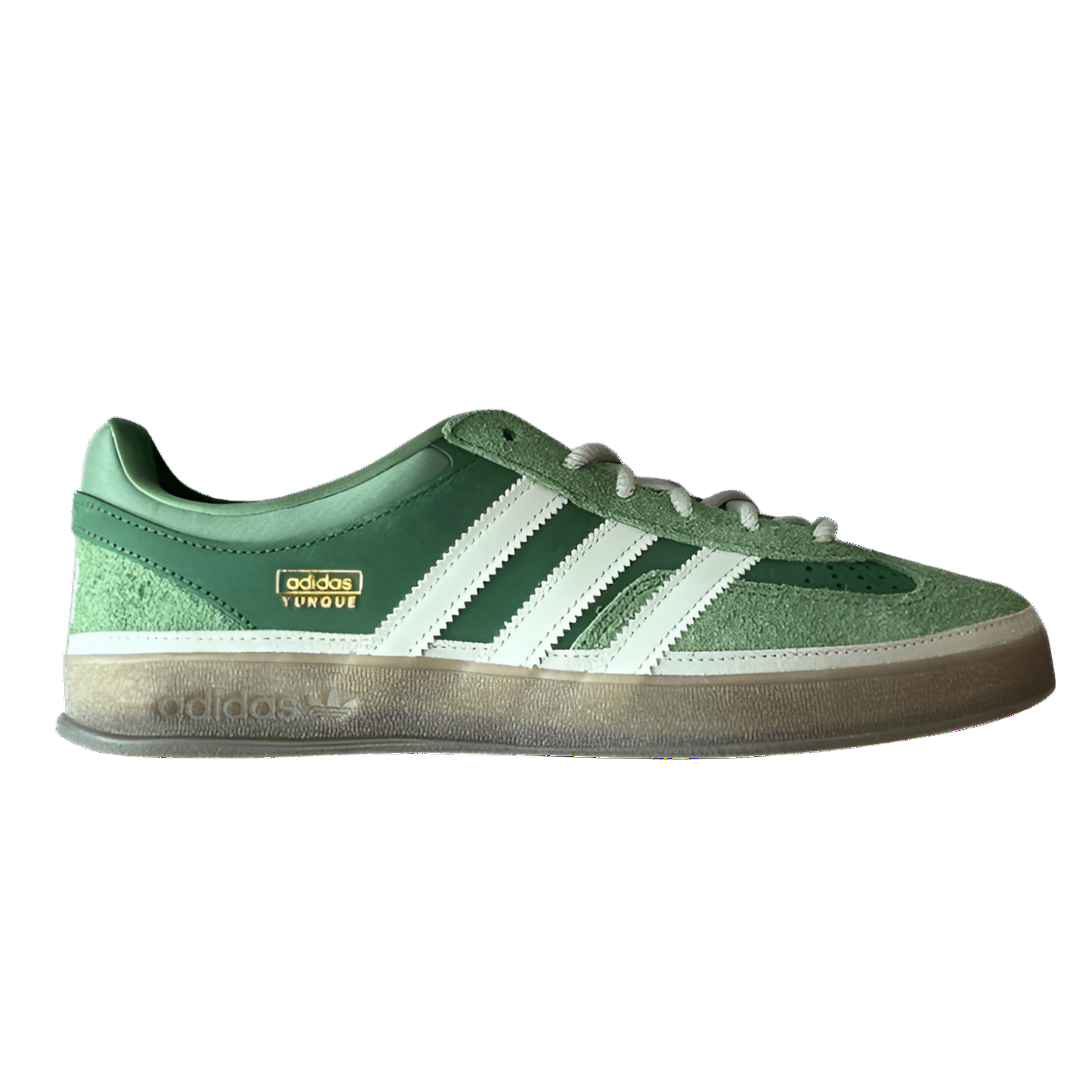 Green Adidas sneaker with white stripes on a white background
