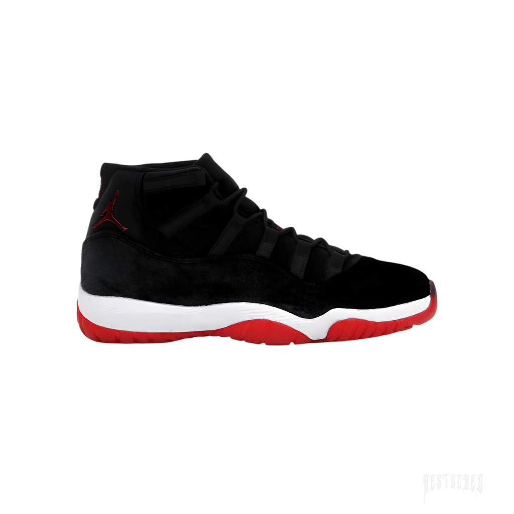 Women's Air Jordan 11 Retro 'Bred Velvet' sneaker with black velvet upper, red Jumpman logo, white midsole, and red outsole.