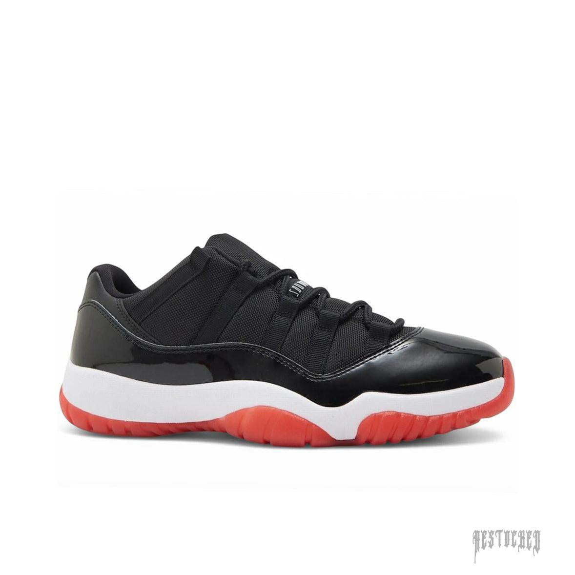 JORDAN 11 RETRO LOW BRED (2025) sneaker, black mesh and patent leather upper, white midsole, red outsole.