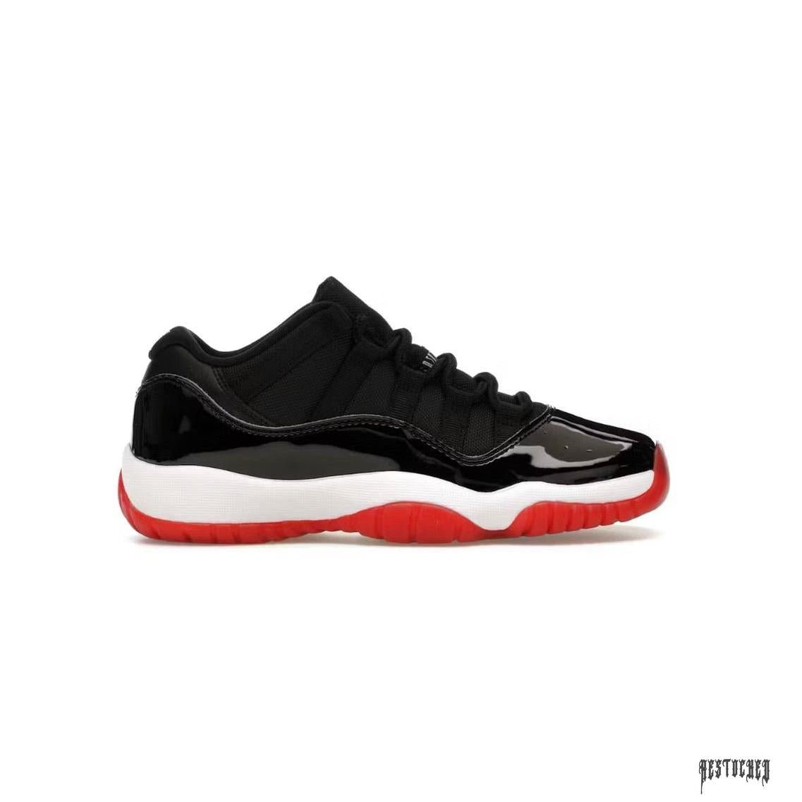JORDAN 11 RETRO LOW BRED (GS) sneaker with black patent leather, mesh upper, white midsole, and red outsole.