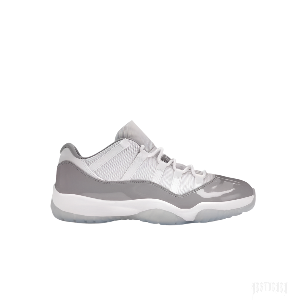 JORDAN 11 Retro Low Cement Grey sneaker, white mesh upper, grey patent leather mudguard, white laces.