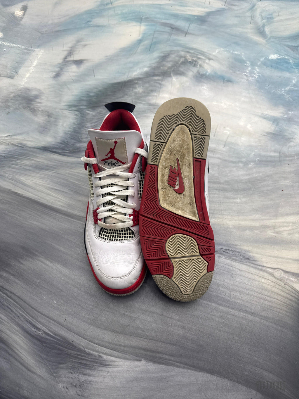 Pre-owned Jordan 4 Retro Fire Red sneakers, white leather with red accents, size 12, showing worn soles.