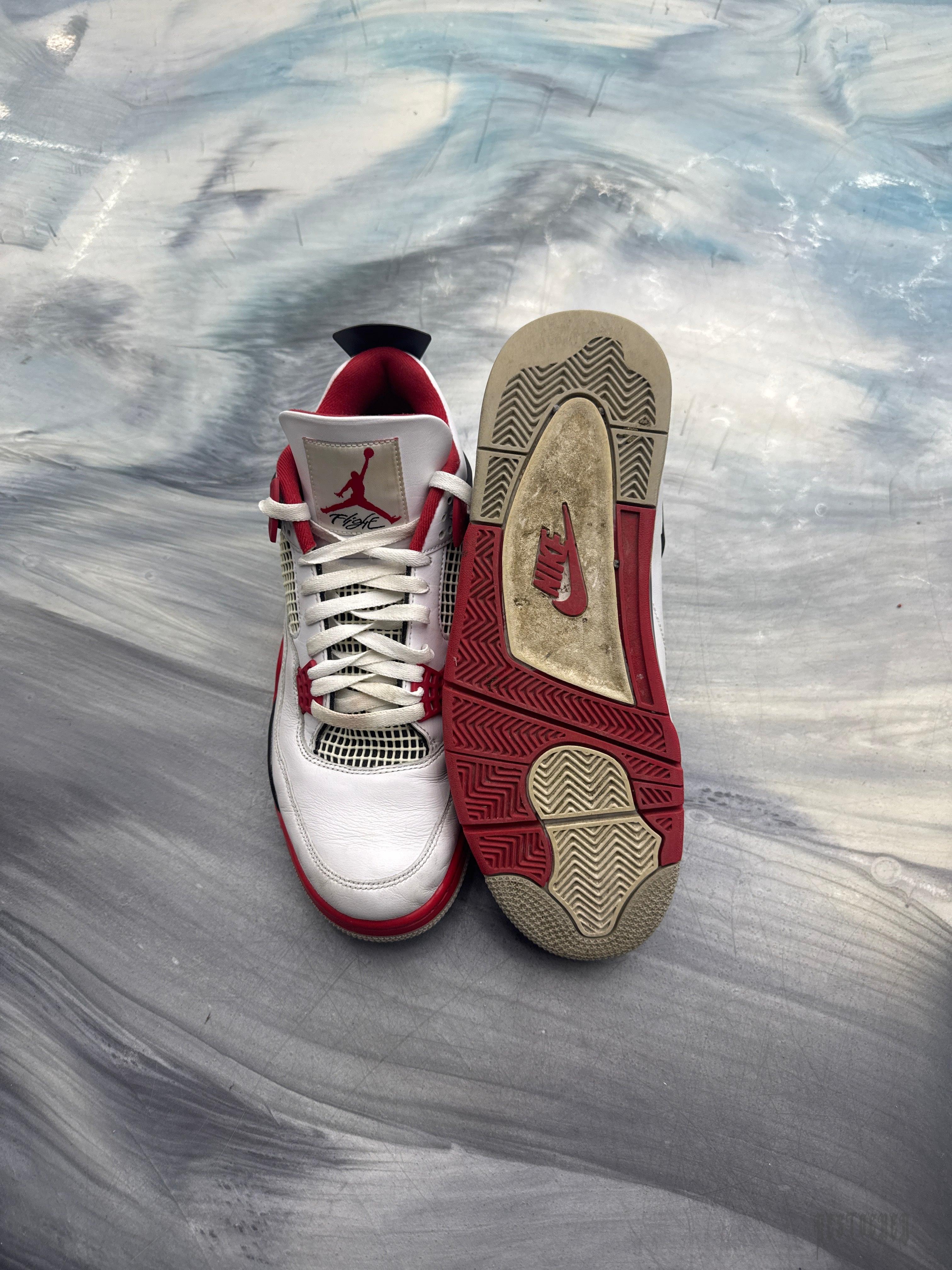 Pre-owned Jordan 4 Retro Fire Red sneakers, white leather with red accents, size 12, showing worn soles.