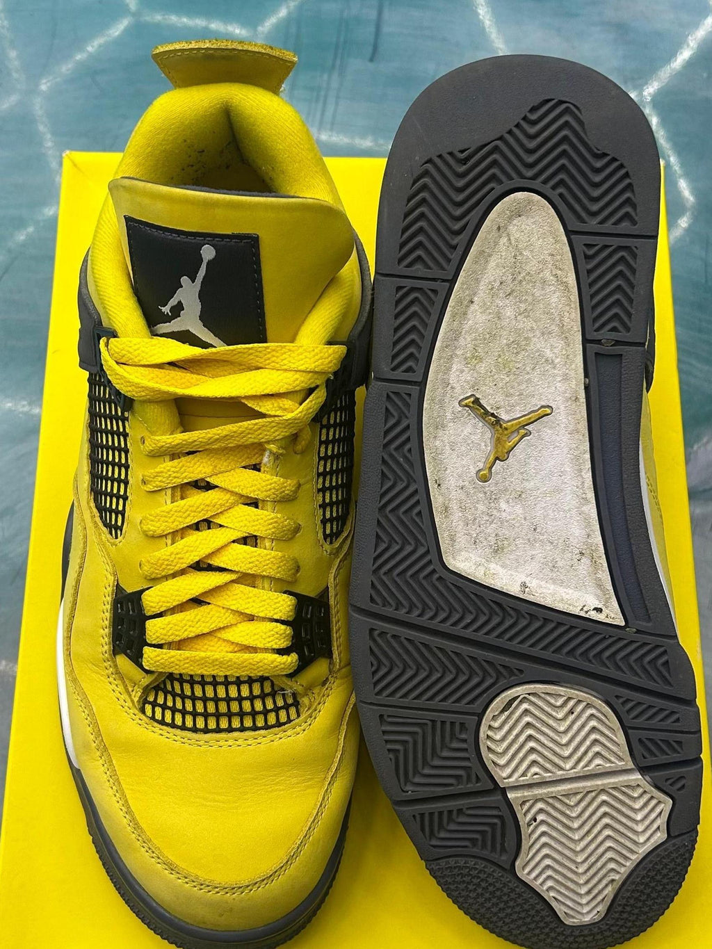 Pre-owned Jordan 4 Retro Lightning sneakers, size 10. Bright yellow leather, black mesh, white Jumpman logo.