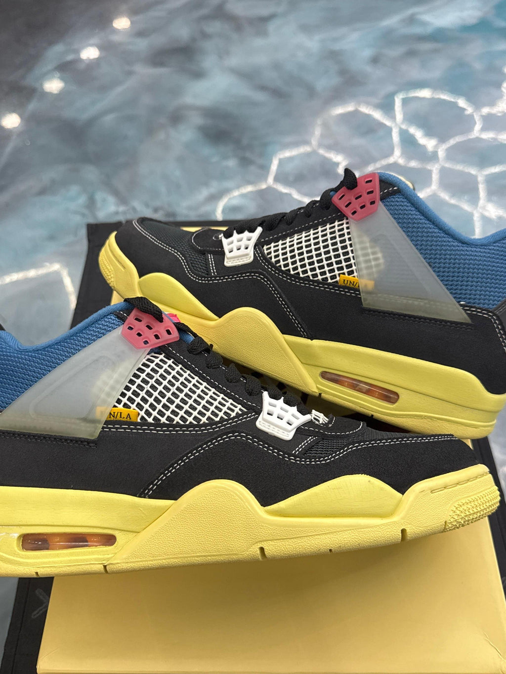 JORDAN 4 Retro Union Off Noir pre-owned size 10.5 sneakers with black suede, blue collar, yellow sole, and white mesh.