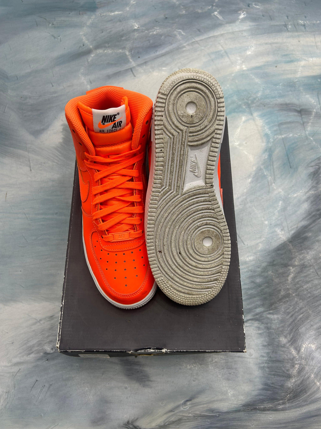 Pre-owned orange Nike Air Force 1 High GS sneakers, one upright, one sole-up, on a box.