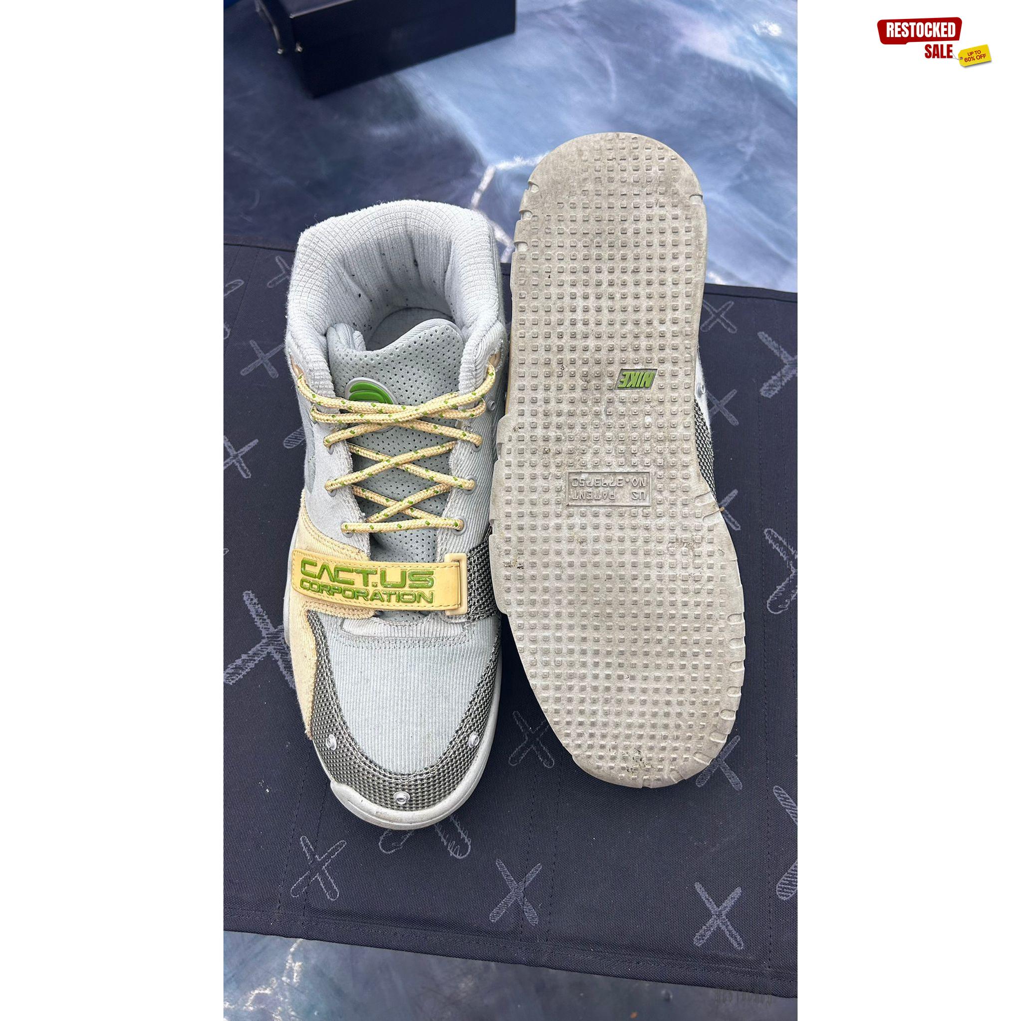 Pre-owned Nike Air Trainer 1 SP Travis Scott Grey Haze size 9.5, top-down view showing grey suede, yellow laces, and "CACT.US CORPORATION" strap.