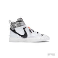 NIKE BLAZER MID READYMADE WHITE sneaker with black swoosh, camo collar, and orange lace accents.