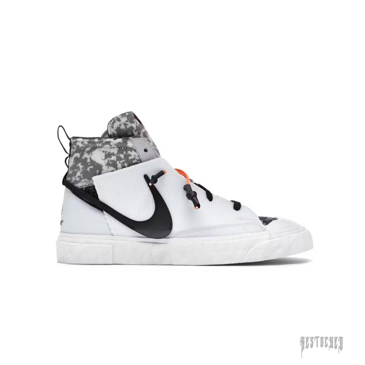 NIKE BLAZER MID READYMADE WHITE sneaker with black swoosh, camo collar, and orange lace accents.