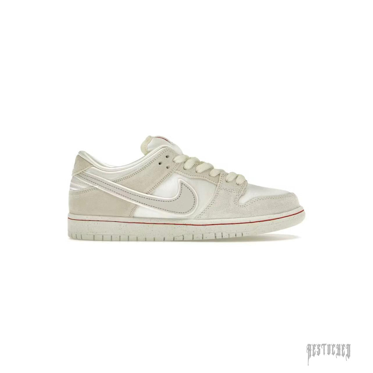 NIKE SB DUNK LOW CITY OF LOVE LIGHT BONE sneaker, featuring light bone suede and satin, with a subtle red sole stripe.