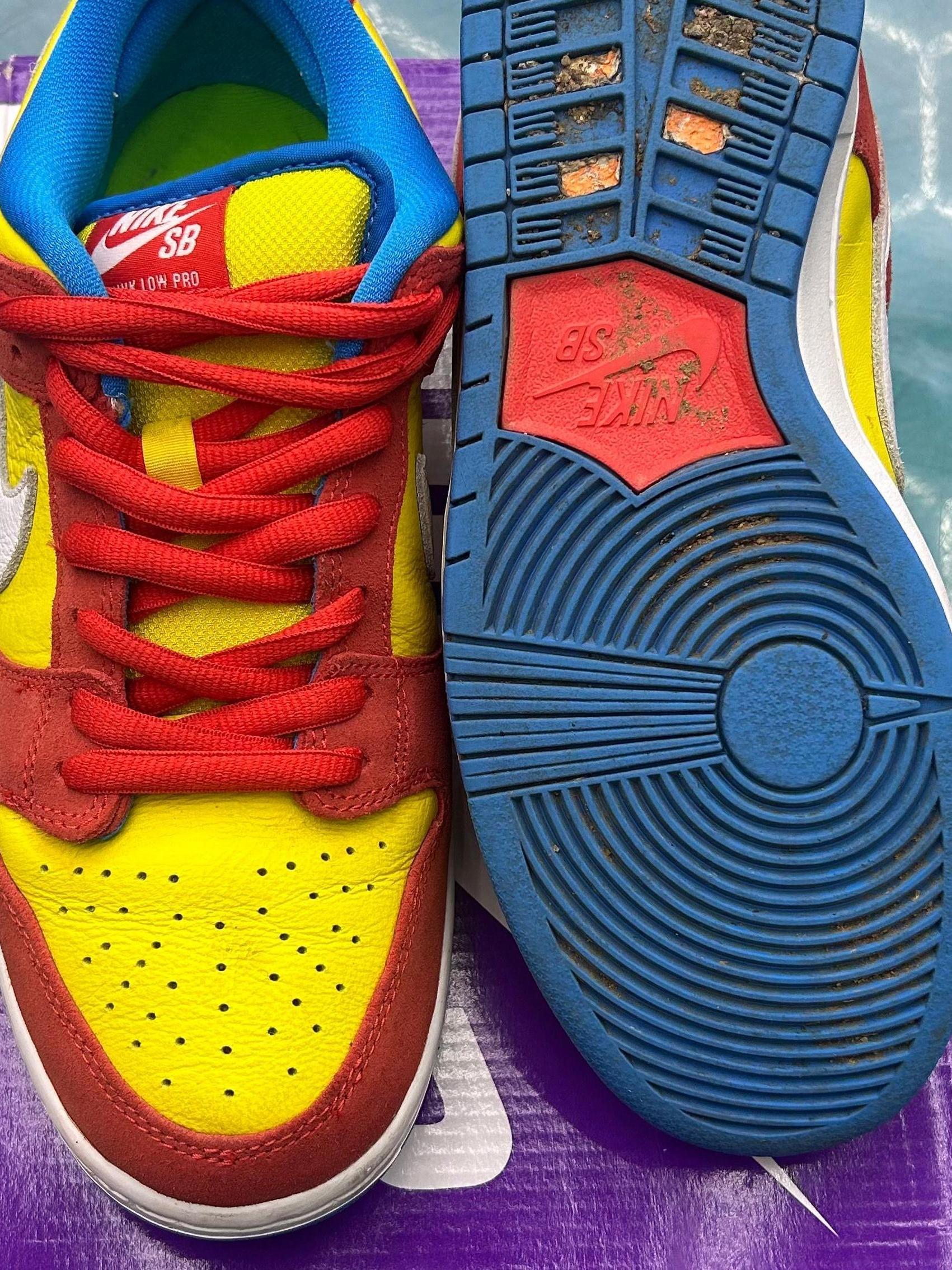 Pre-owned NIKE SB Dunk Low Pro Bart Simpson sneakers, red, yellow, and blue, size 9.5, showing wear.