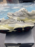 New Balance 9060 Rain Cloud Grey pre-owned sneakers, size 8.5, with mesh and suede upper, cream midsole, and black/red outsole.